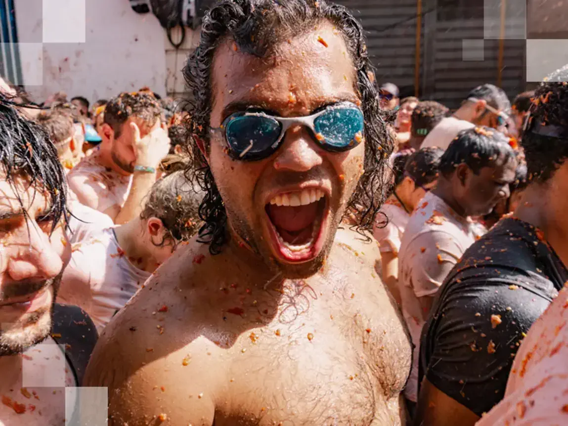 Equipped with goggles to keep all the tomato out of their eyes revellers soak in the festive atmosphere (and tomato juice). © Miles Holder
