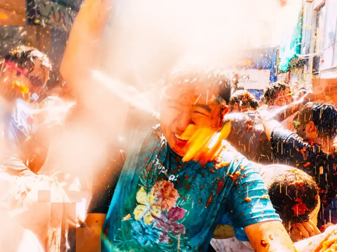 Tomatoes begin flying through the air indiscriminately covering revellers (and cameras!) alike. © Miles Holder