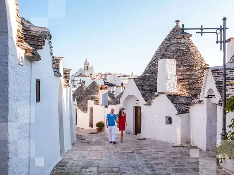Tourist couple visiting the Trulli area, Alberobello, Itria valley, Apulia, Italy (MR)